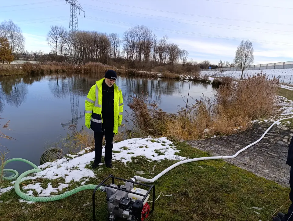 Schulungsteilnehmer am Teich mit Wasserpumpe