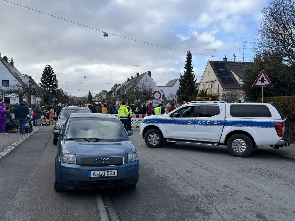Viele Menschen hinter Autos
