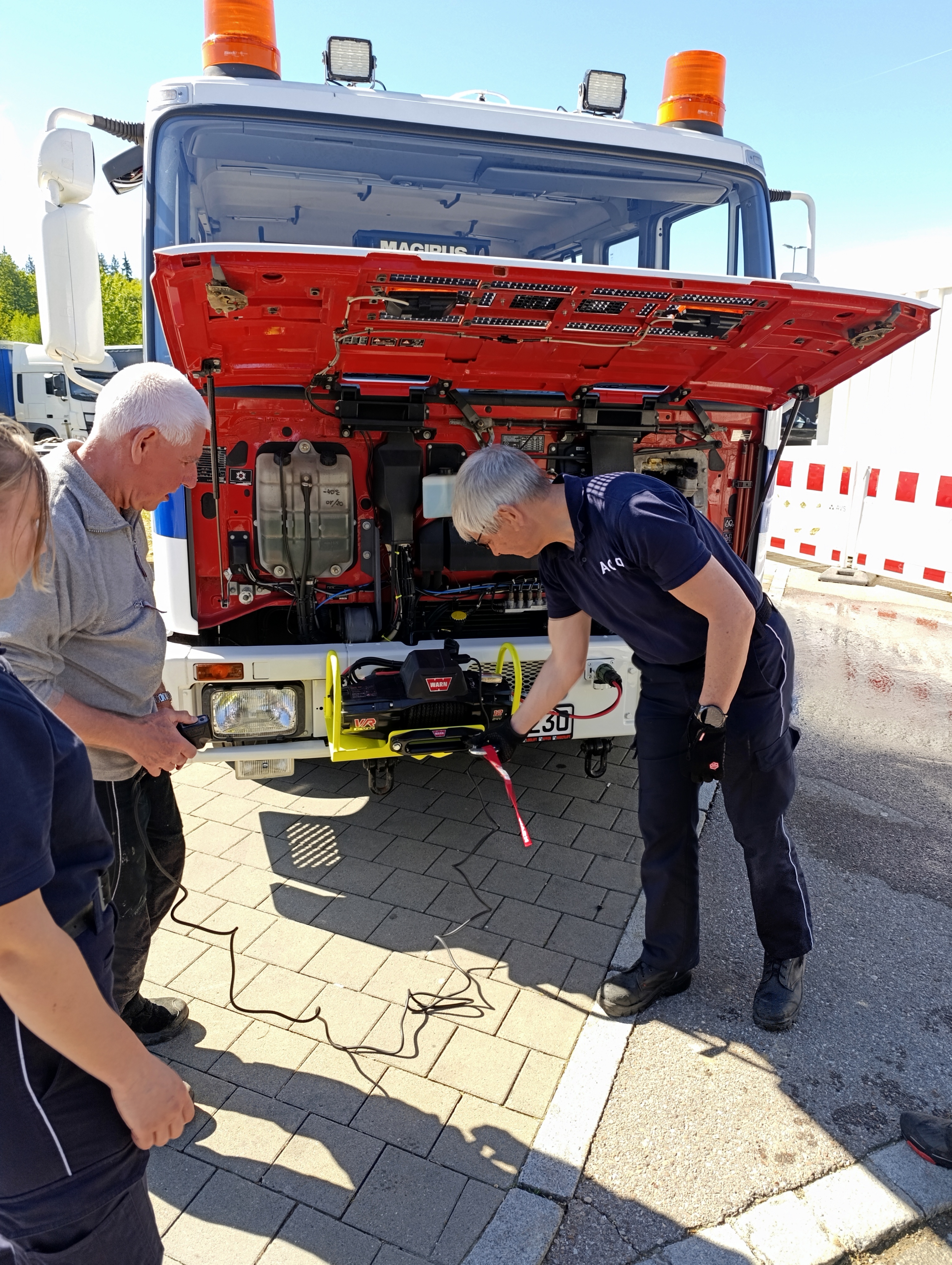 Leute stehen vor dem LKW testen die Seilwinde