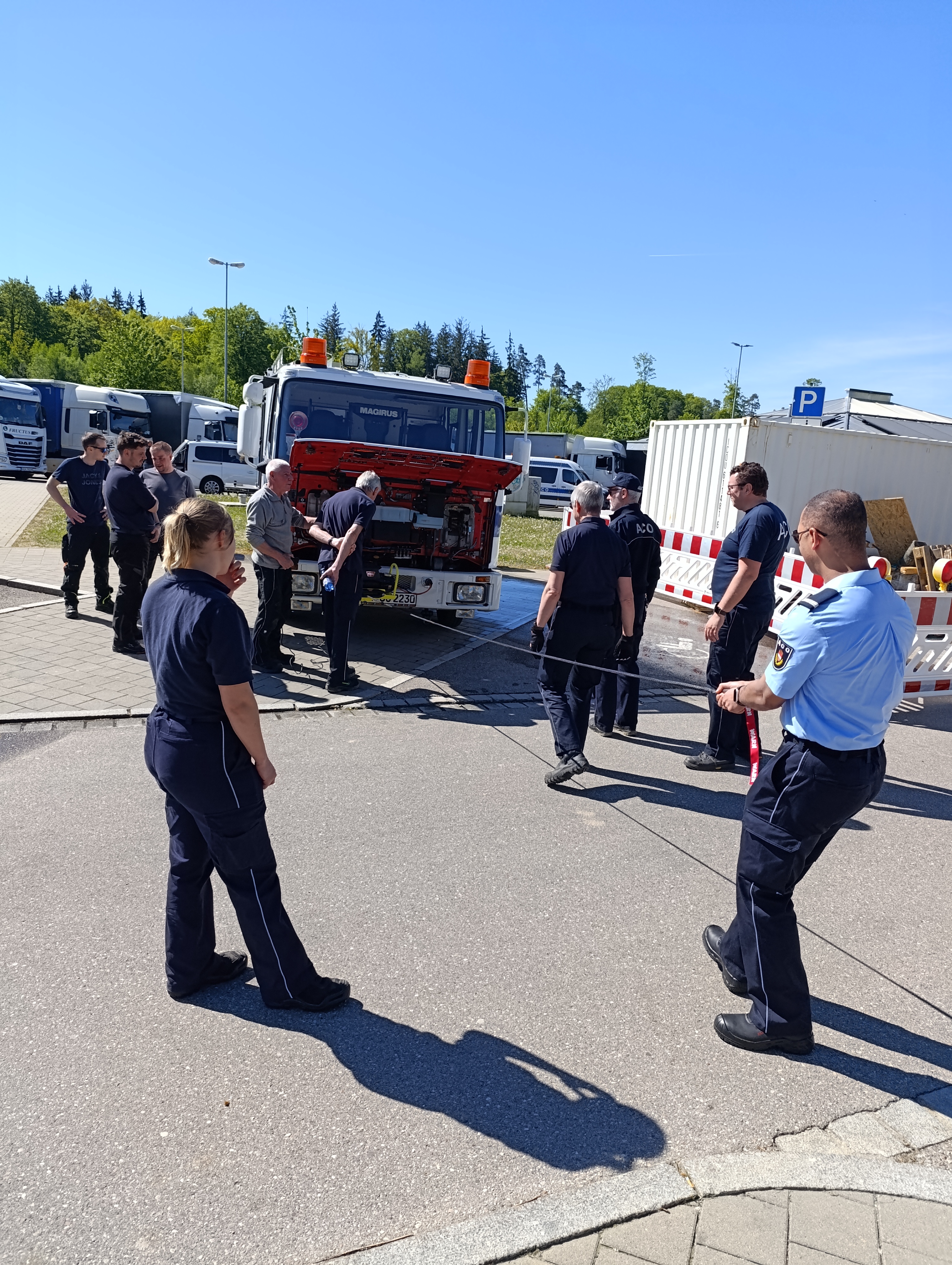 Leute stehen vor dem LKW testen die Seilwinde